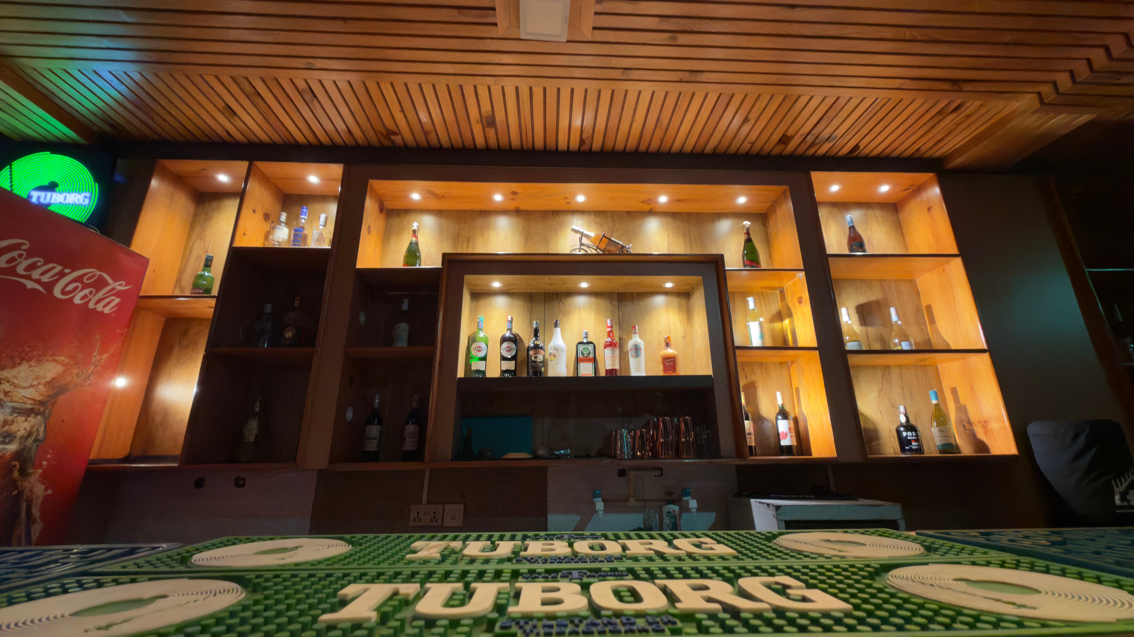 The back bar with bottles displayed in warm timber niches